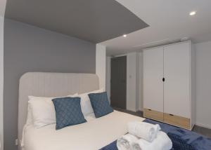 a bedroom with a white bed and a chair at Donington Cottage Apt 8 in Castle Donington