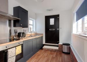 cocina con puerta negra y suelo de madera en Donington Cottage Apt 8 en Castle Donington