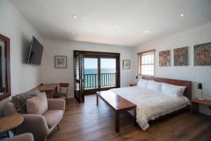 a bedroom with a bed and a living room at Bantry Bay Home with Atlantic Ocean Views in Cape Town