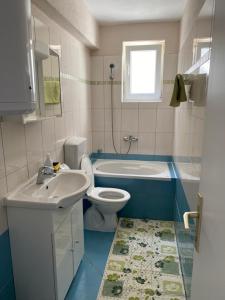 ein Badezimmer mit einem Waschbecken, einem WC und einer Badewanne in der Unterkunft Villa Lovric in Marina