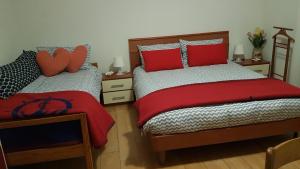 1 dormitorio con 2 camas y almohadas rojas en B&B Kristina en Quinto Vicentino