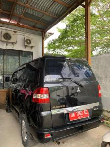 a black minivan parked in a garage at Jambura Inn in Gorontalo