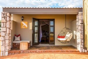 a small house with a porch with a swing at Gondwana Kalahari Anib Lodge in Hardap