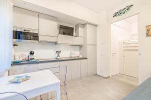 a kitchen with white cabinets and a table and chairs at La Perla del Mare, Terre Marine in Monterosso al Mare
