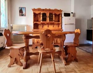 een houten tafel met stoelen en een houten kast bij CASA NELLY in Andalo