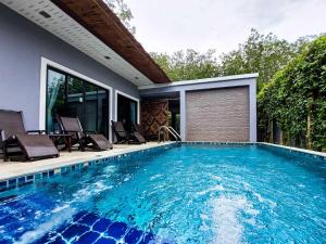 a swimming pool with chairs and a house at Ton Yaang private pool villa in Ao Nang Beach