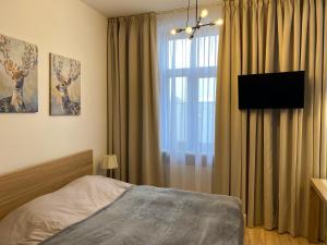Un dormitorio con una cama y una ventana con cortinas. en Apartament w centrum, en Kościerzyna