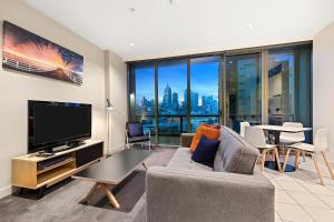 a living room with a couch and a tv at Southbank Apartments Freshwater Place in Melbourne