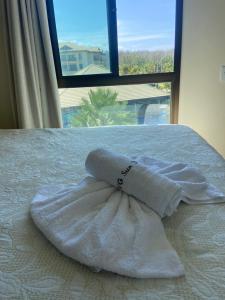 a towel sitting on top of a bed with a window at Vg Sun cumbuco 310 c4 in Cumbuco