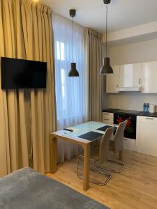 a kitchen with a table and chairs and a kitchen with a television at Apartament w centrum in Kościerzyna