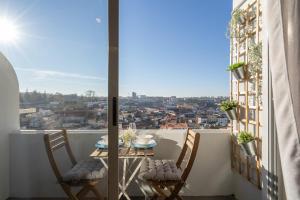 uma varanda com uma mesa e cadeiras e uma vista em Gaya Avenue Flats - Elegant Contemporary Flats with Balcony em Vila Nova de Gaia