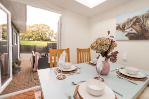 una sala da pranzo con tavolo bianco e vaso di fiori di Sleepy Hollow a Dover