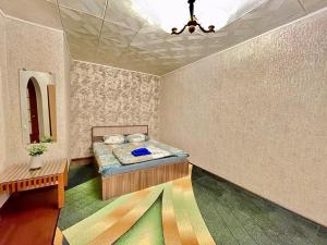 ヴォルクタにあるApartment TwoPillows on Parkovaya 40aのベッドルーム1室(ベッド1台、テーブル付)