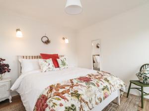Schlafzimmer mit einem Bett mit weißen Wänden und roten Kissen in der Unterkunft Sleepy Hollow in Dover