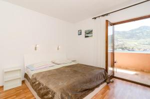 a bedroom with a bed and a large window at Apartments Bezek in Trstenik