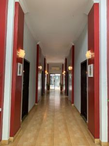 an empty hallway in a building with red and white walls at Jambura Inn in Gorontalo