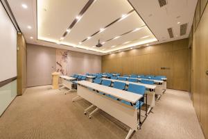 una sala de conferencias vacía con sillas y escritorios azules en Atour Hotel Langfang Railway Station en Langfang