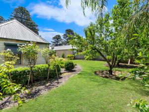 un cortile con alberi e una casa di Lavender Cottage a Port Fairy