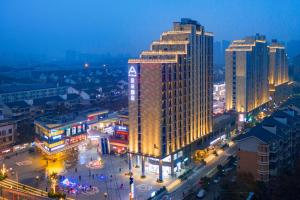 a city lit up at night with a tall building at Atour Hotel Wuhan Guanggu Qingnianhui JinRongGang in Wuhan