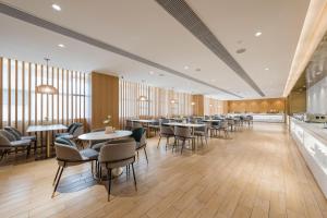 a restaurant with tables and chairs in a room at Atour X Hotel Wuxi New Zone Gelunbu Plaza in Wuxi