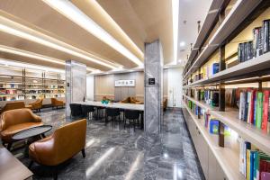 a library with a long table and chairs and bookshelves at Atour Hotel Hengyang West Jiefang Road City Hall in Hengyang