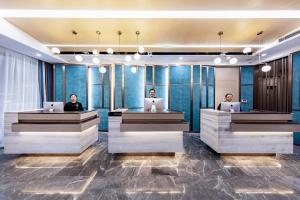 two people sitting in a lobby with their laptops at Atour Hotel Hengyang West Jiefang Road City Hall in Hengyang