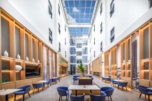 a cafeteria with tables and chairs in a building at Atour Hotel Xiamen Jimei Lake Business Center in Xiamen