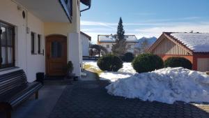 um monte de neve em frente a uma casa em La Locanda Ristorante Pizzeria Garni em Ohlstadt