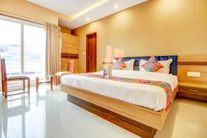 a bedroom with a bed and a table and a window at FabHotel 7th Crossing in Jaipur