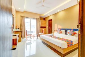 una camera con letto, tavolo e sedie di FabHotel 7th Crossing a Jaipur