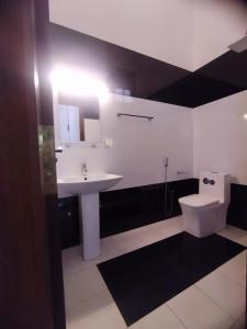 a bathroom with a white sink and a toilet at Kolition Villa in Dickwella