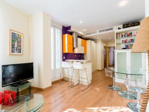 sala de estar con TV y mesa en Holi-Rent Goya, en Sevilla