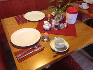 una mesa de madera con platos y utensilios. en La Locanda Ristorante Pizzeria Garni, en Ohlstadt