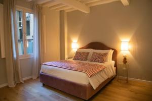 1 dormitorio con 1 cama con 2 lámparas y una ventana en Lunaria Suites, en Florencia