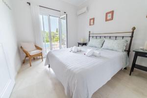 a bedroom with a large white bed and a window at Villa Adonis in Halikounas +32 photos