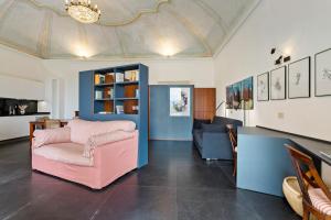 a living room with a pink chair and a couch at Villa Bel Faggio Apartment by Halldis in Menaggio