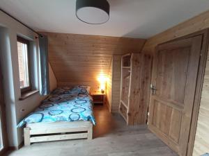 a bedroom with a bed in a wooden room at Domek w Cisnej pod Honem 2 in Cisna