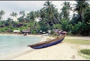 a blue boat sitting on the shore of a beach at Sunny Mood Guest House in Unawatuna