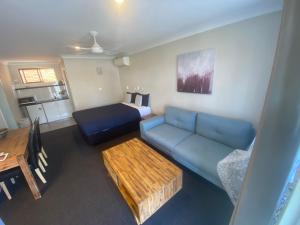 a living room with a blue couch and a table at Woongarra Motel in North Haven