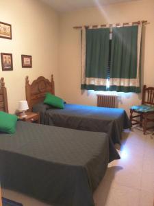 a bedroom with two beds and a window at CASA RURAL RECIRUELOS in Peguerinos
