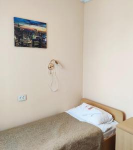 1 dormitorio con 1 cama y teléfono en la pared en Patriot, en Kaliningrado