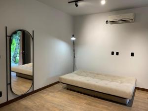 1 dormitorio con cama y espejo en Verona Parque Hotel, en Veranópolis