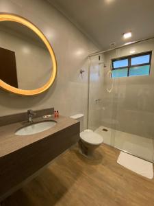 uma casa de banho com um lavatório, um WC e um espelho. em Verona Parque Hotel em Veranópolis
