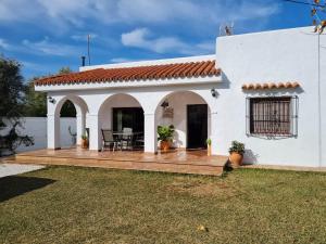 una terraza de madera frente a una casa blanca en La Morera, El Palmar, en El Palmar