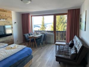 a bedroom with a couch and a table and a balcony at Ferienwohnung Oberallgäu Ferienpark mit Schwimmbad in Missen-Wilhams