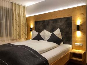 una camera da letto con un grande letto con cuscini bianchi e neri di Badererhof Christine Wechselberger a Stumm