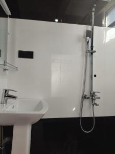 bagno bianco con lavandino e doccia di Kolition Villa a Dikwella