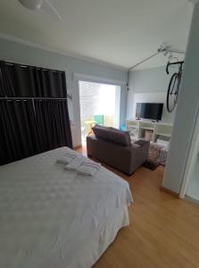 ein Schlafzimmer mit einem weißen Bett und einem Sofa in der Unterkunft Hotel Montana Serra Negra in Serra Negra