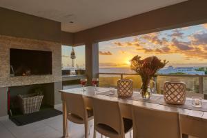 a dining room with a table and a view of the ocean at Stanford's Cove Villas in Gansbaai