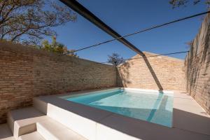 - une piscine sur le côté d'un mur de briques dans l'établissement Villa Cipressi by Victoria Palace, à Pesaro